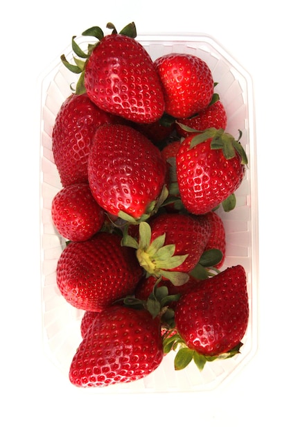 Fraises douces fraîches dans un récipient en plastique