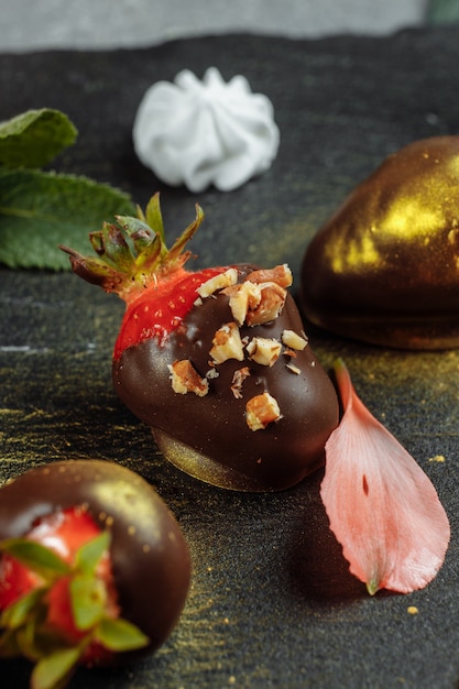 Fraises enrobées de chocolat frais sur un fond décoratif gris. Concept pour la publicité du menu saisonnier d'été.