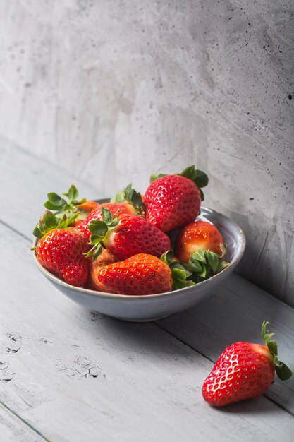 Fraises espagnoles fraîches dans un bol sur une table gris rustique