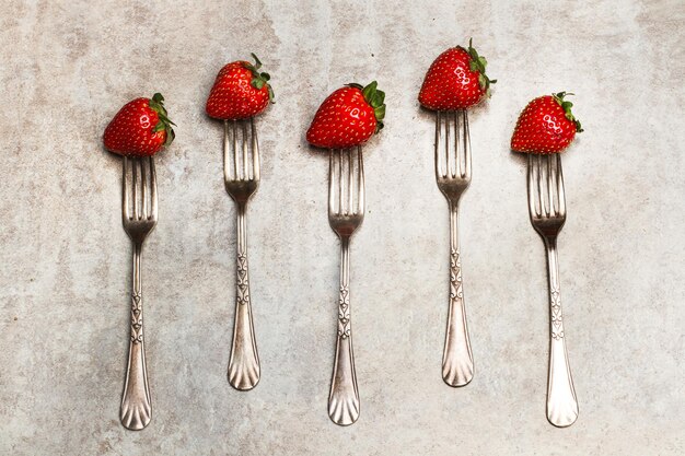 Fraises et fourchettes sur une table en marbre en vue de dessus