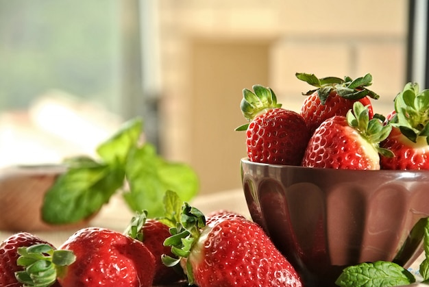 Fraises fraîches sur une assiette et un tissu brun