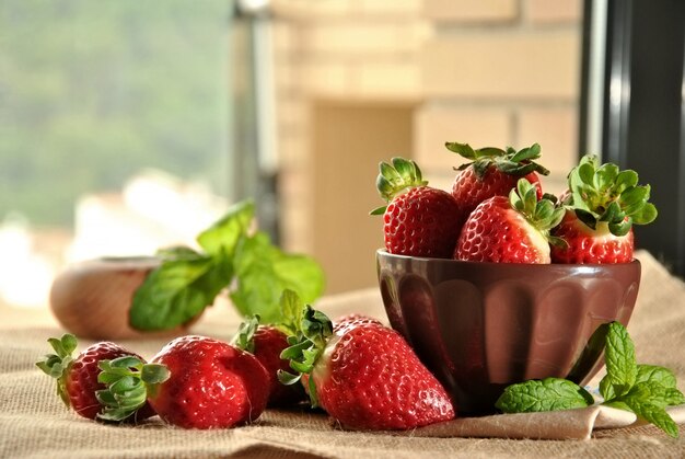 Fraises fraîches sur une assiette et un tissu brun