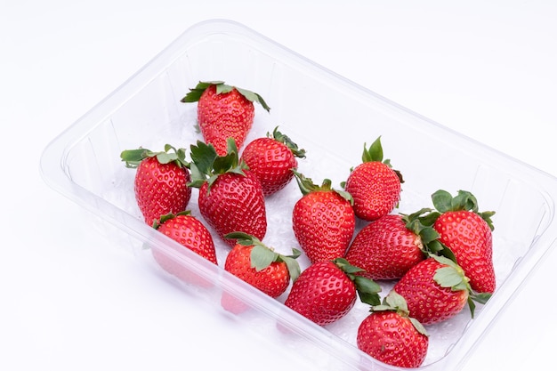 Fraises fraîches en barquette en plastique, prêtes à être consommées