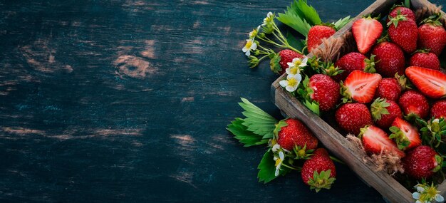 Fraises fraîches dans une boîte en bois Sur un fond en bois Vue de dessus Espace de copie