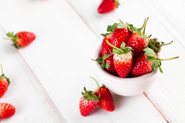 Fraises fraîches dans un bol sur une table en bois