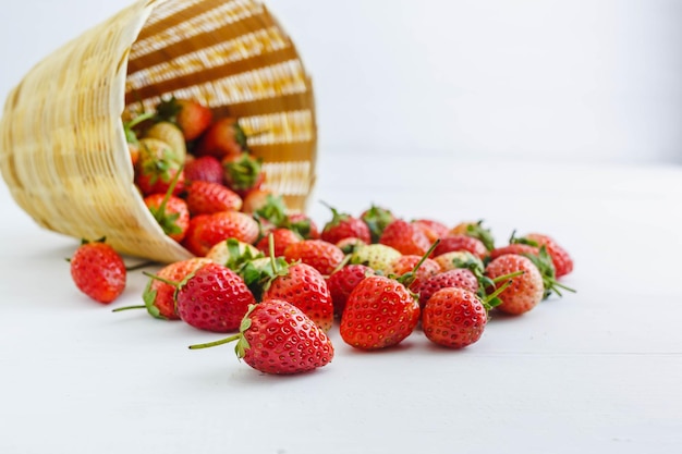 Fraises fraîches dans un panier sur fond blanc