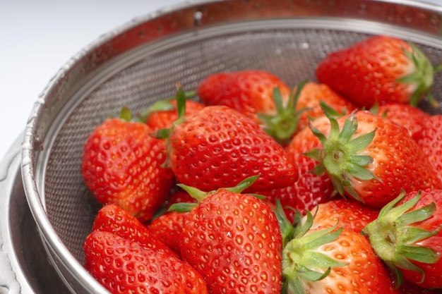 Fraises fraîches dans un panier sur fond blanc