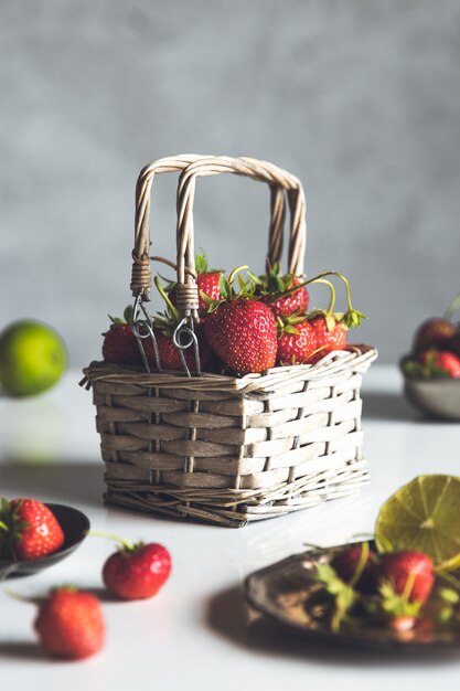 Fraises fraîches dans un panier sur table en bois blanc