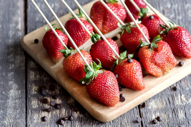 Fraises fraîches Fraises rouges Belles fraises sur des brochettes Fraises sur planche de bois