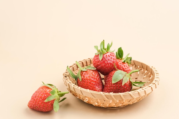 Fraises fraîches juteuses avec des feuilles servies dans un panier en bambou Mise au point sélectionnée