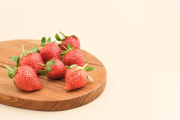 Fraises fraîches juteuses avec des feuilles servies sur une planche à découper Mise au point sélectionnée