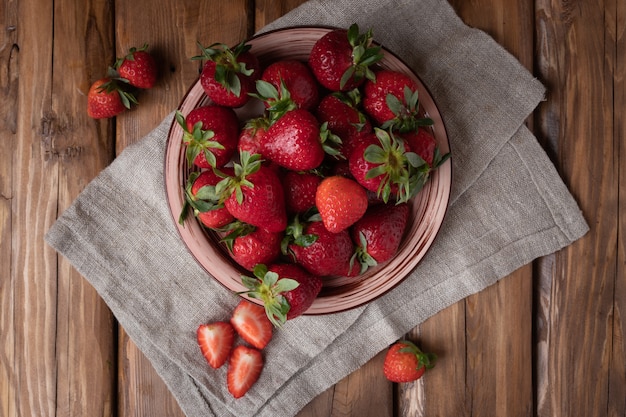 Fraises fraîches et juteuses sur un fond en bois