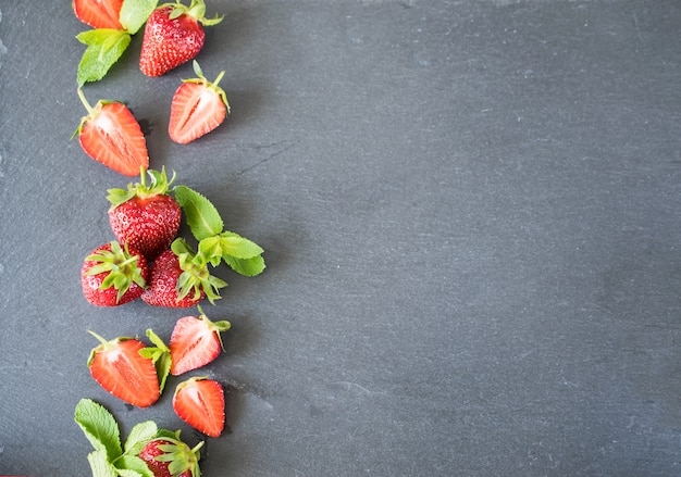 Fraises fraîches et juteuses sur un tableau d&#39;ardoise