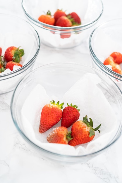 Des fraises fraîches et moisies dans un bol de verre sur une serviette blanche