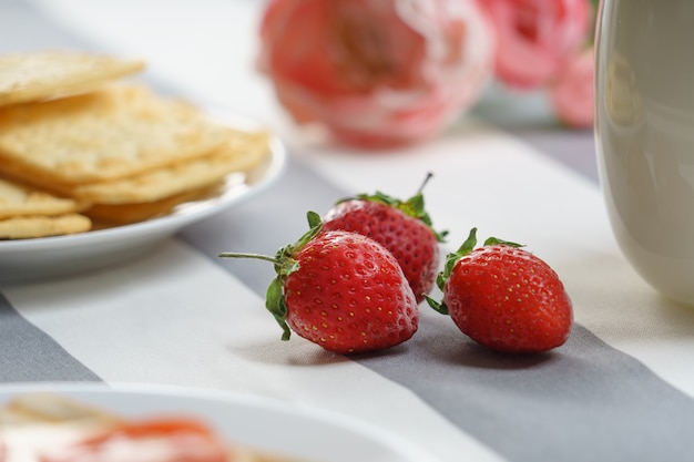 Photo fraises fraîches et savoureuses pour le petit déjeuner sur un fond clair.