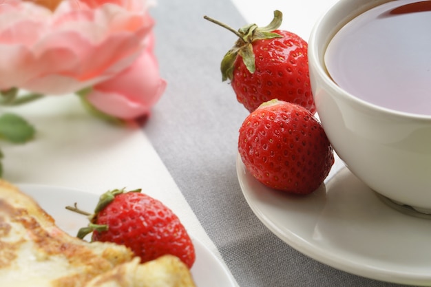 Fraises fraîches et savoureuses pour le petit déjeuner sur un fond clair.