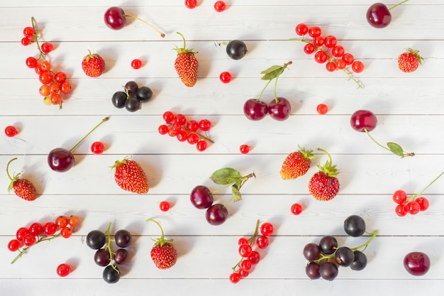 fraises, groseilles et cerises sur une table blanche