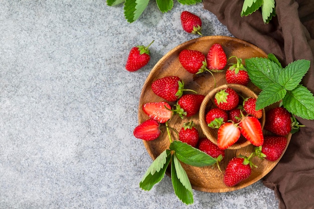 Fraises juteuses dans un bol avec des feuilles sur un comptoir en pierre grise ou en ardoise Vue de dessus Espace de copie