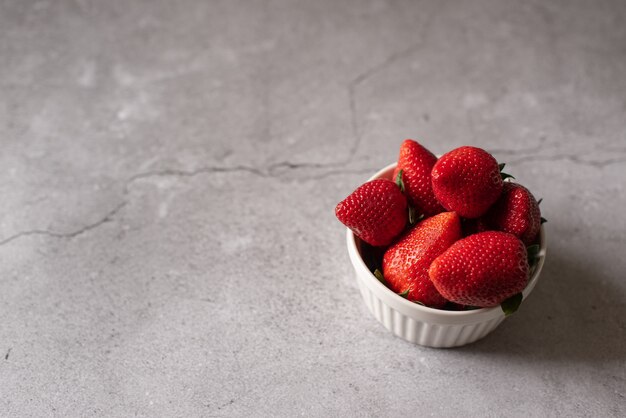 Fraises mûres complet du corps dans une rangée et des moitiés isolées