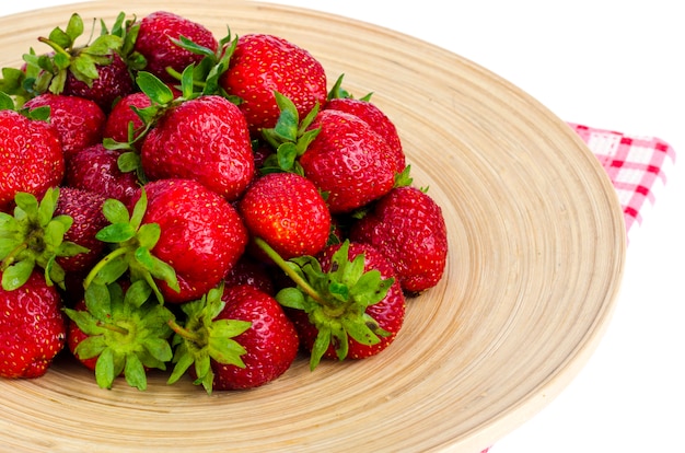 Fraises mûres du fermier rouge sur un plat en bois