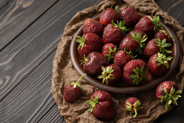 Fraises mûres sur un fond rustique foncé