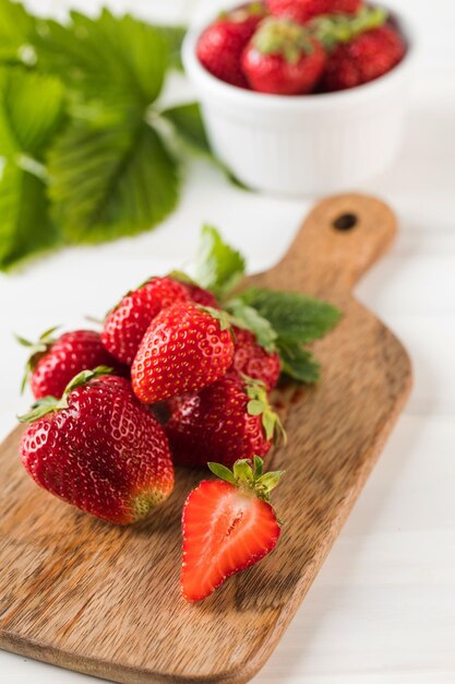 Fraises mûres fraîches sur une planche de bois