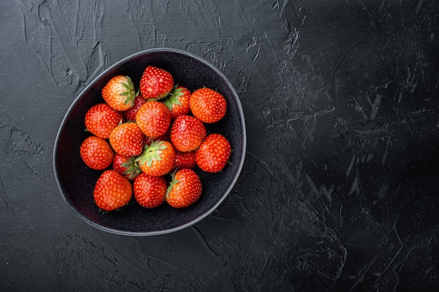 Fraises mûres fraîches sur une plaque noire