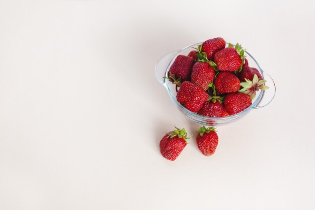 Fraises mûres juteuses dans un bol isolé sur fond blanc avec un espace pour le texte