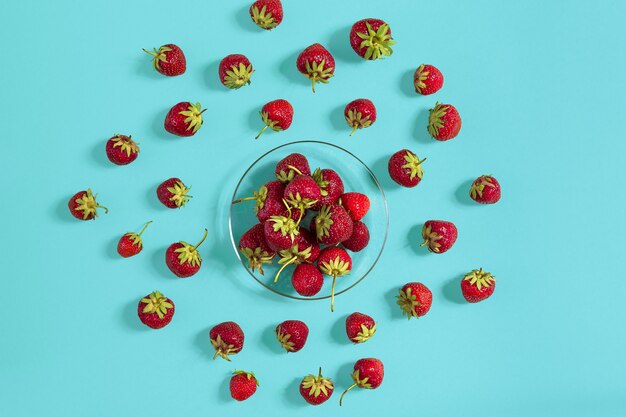 Fraises mûres sur la soucoupe isolées sur fond de menthe. Vue de dessus. Espace de copie. Maquette de nature morte à plat