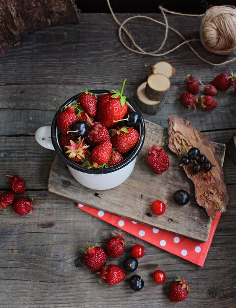 fraises de petits fruits rouges, fond rustique en bois. Produits naturels biologiques.