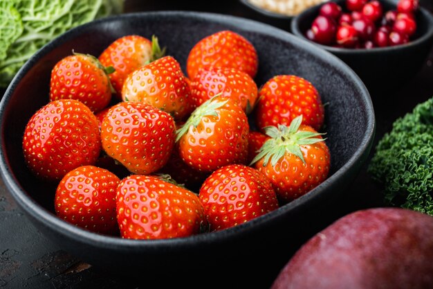 Fraises rouges mûres dans un bol noir