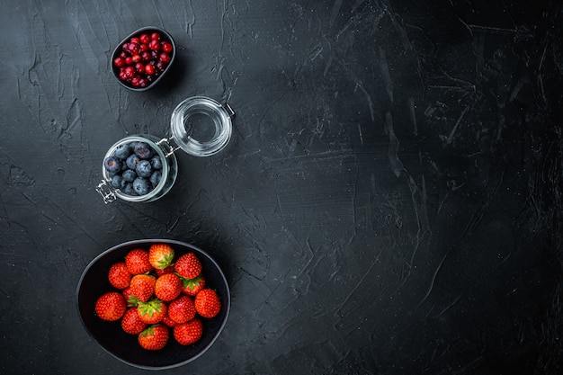 Fraises rouges mûres dans un bol noir