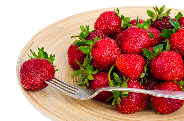 Fraises rouges mûres sur plat en bois