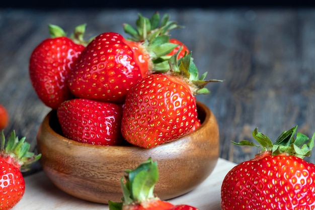 Fraises rouges mûres se trouvant sur un plateau en bois