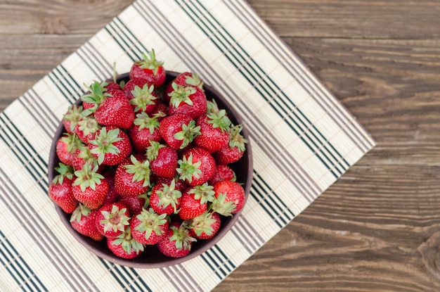 Fraises rouges mûres sur table en bois