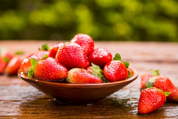 Photo fraises rouges mûres sur table en bois