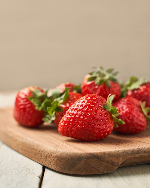 Fraises rouges sur une planche de bois avec lumière