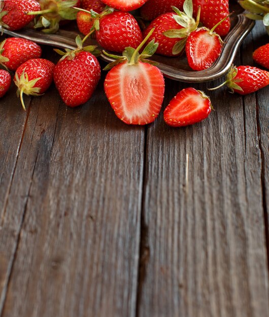 Fraises sur une table en bois sombre se bouchent