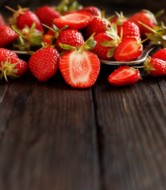 Fraises sur une table en bois sombre se bouchent