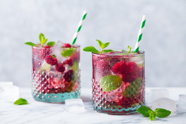 Photo framboise cocktail fizz limonade thé glacé à la menthe fraîche sur fond de marbre close up