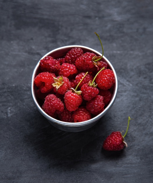 framboise douce dans un bol sur fond gris foncé. Vue de dessus et espace de copie