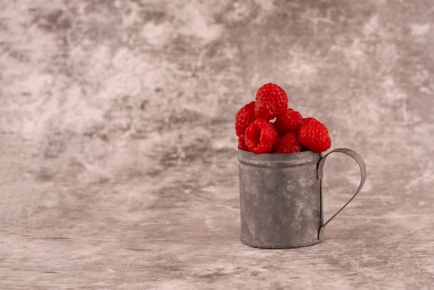 Framboise fraîche dans une tasse sur fond marron Copier l'espace