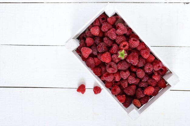 Framboise rose juteuse fraîche dans une boîte en bois