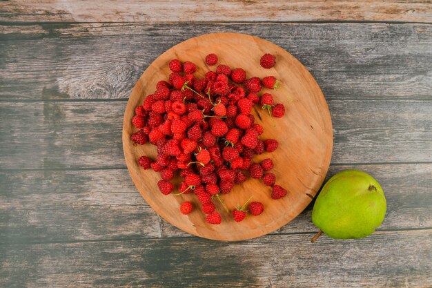 Framboises au citron sur un fond en bois. Blocs de bois avec les mots vitamine C, fruits frais en arrière-plan, alimentation saine ou concept de régime alimentaire. Vue d'en-haut. Un endroit pour écrire.