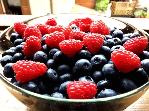 Framboises et bleuets dans un bol sur la table