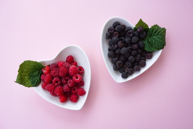 Framboises dans un bol blanc avec un fond rose