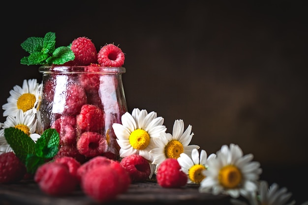 Framboises dans une tasse sur fond sombre