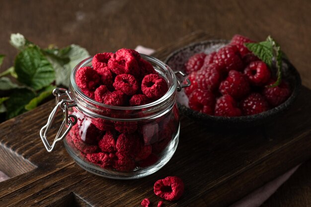 Framboises lyophilisées dans un bocal en verre sur fond de bois