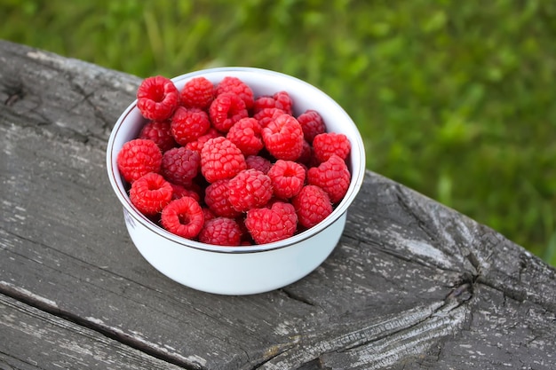 Framboises mûres douces fraîches sur fond de nature