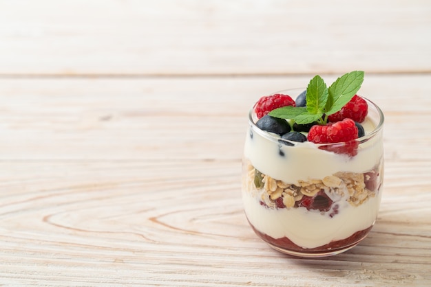 Framboises et myrtilles maison avec yogourt et granola - style alimentaire sain